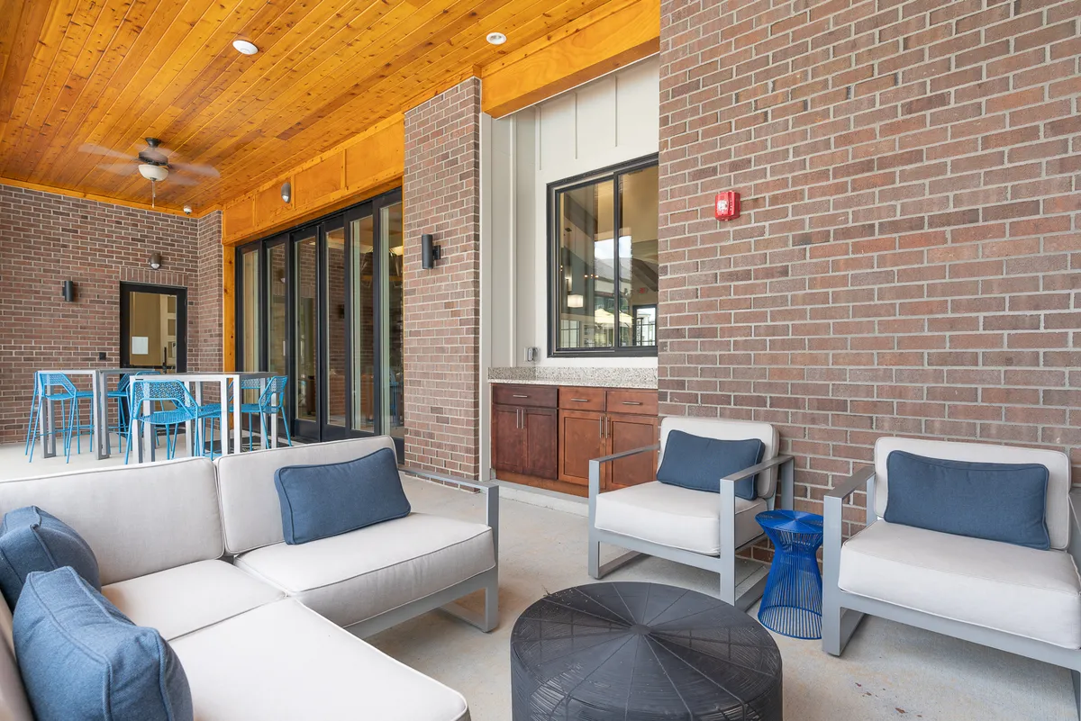 A bright, open-plan living space featuring a comfortable seating area, a stylish bar counter, and large glass doors that let in natural light. The space feels welcoming and is arranged for both relaxation and socializing, emphasizing the apartment's ready-to-enjoy atmosphere.
